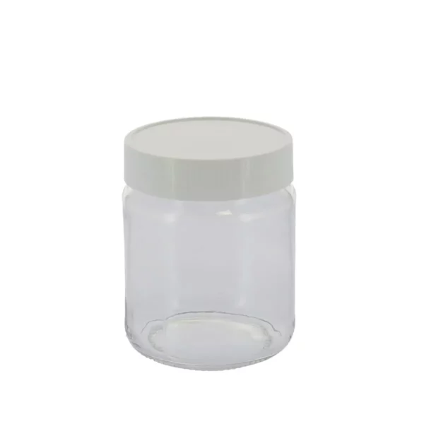 Cette photo montre le pot de yaourt en verre, de la marque Home Equipement, avec son couvercle à visser. Il est vu de face, et dans son ensemble. Le pot en verre est fermé par son couvercle