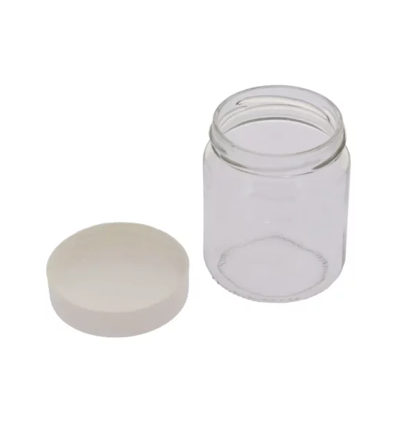 Cette photo montre un pot de yaourt en verre, avec son couvercle à visser, de la marque Home Equipement. Le couvercle est dévissé et se trouve a côté du pot